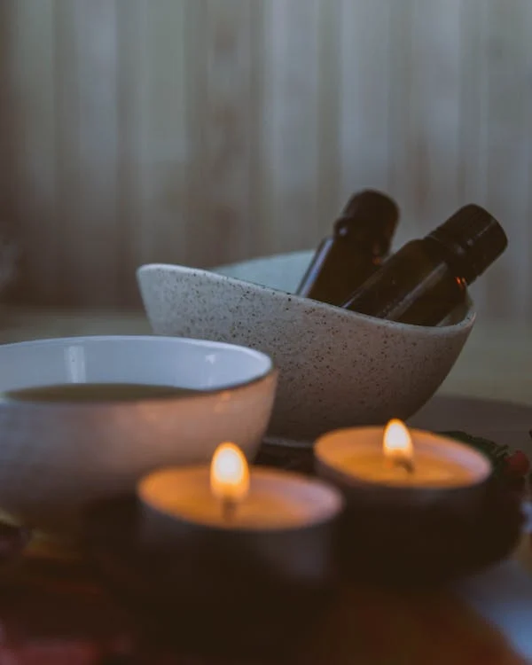 An image of candles and bottles in bowls