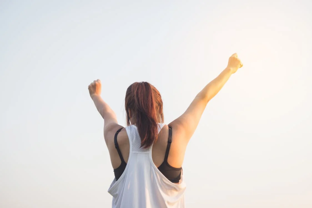 An image of a person raising both their hands toward the sky