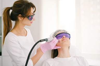 An image of a professional female performing laser treatment for hair removal on a client