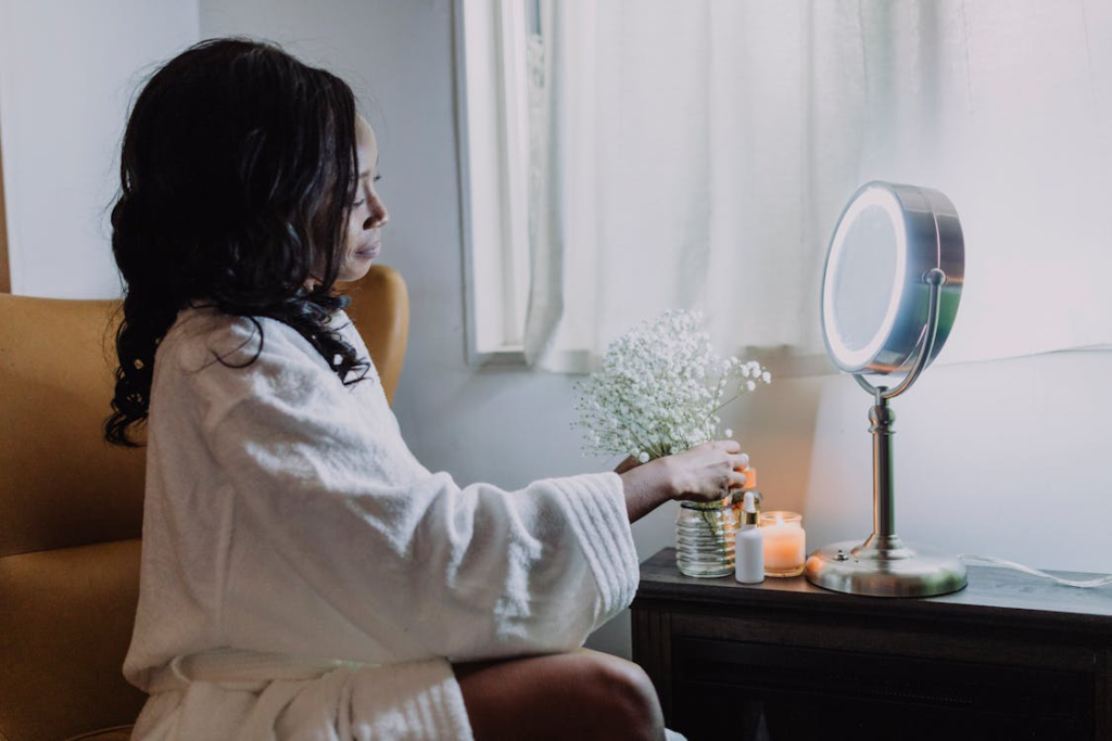 An image of a woman wearing a robe and sitting in front of a mirror