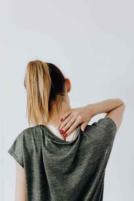 An image of a person touching their neck