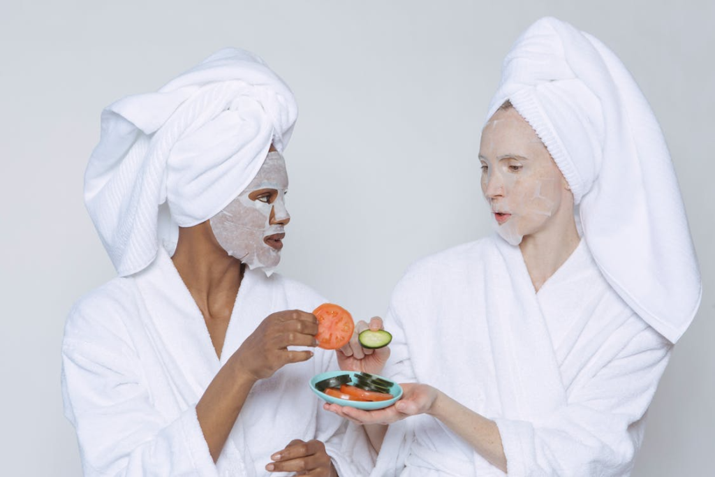 An image of two women in bathrobes eating vegetables      