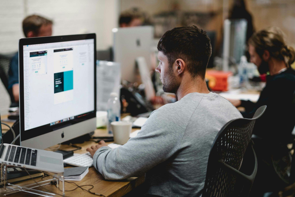 a person working on a computer desktop while sitting in a chair