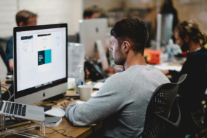 a person working on a computer desktop while sitting in a chair