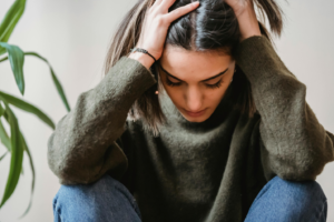 Stressed woman looking down with her head in her hands