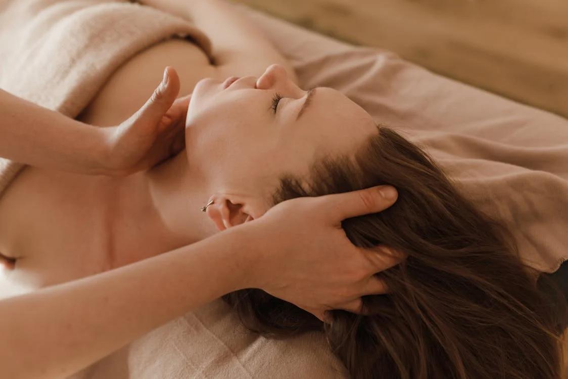 a woman getting a head and neck massage from a massage therapist