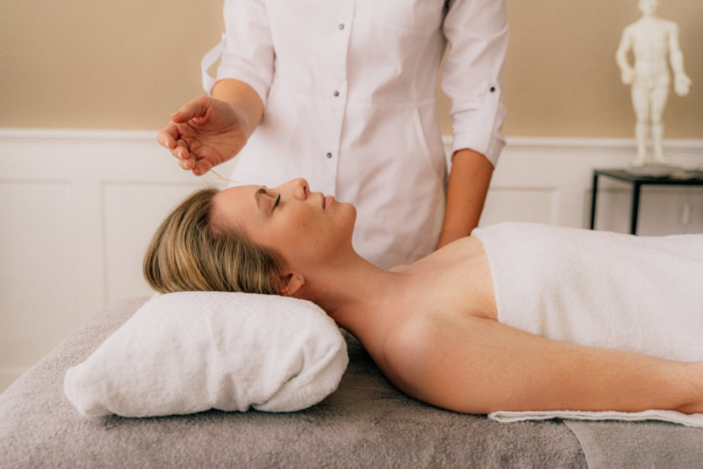 A therapist providing a calming therapeutic massage to a client lying on a table.