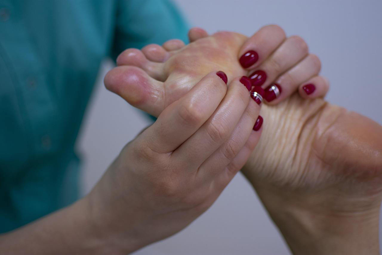 Therapist performing a detailed foot reflexology massage.