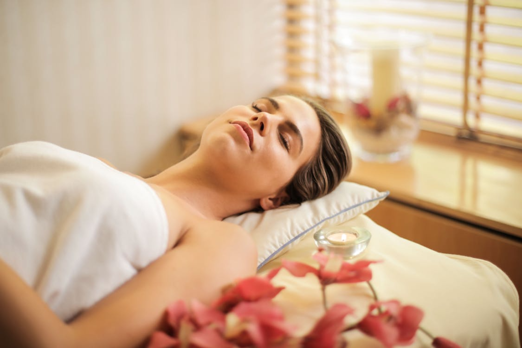 Woman lying down for a luxury massage with candles and flowers at a massage center in Edmonton.