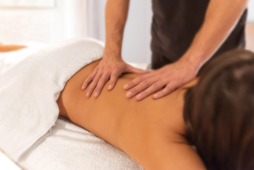 Therapist providing back massage therapy to relieve tension and stress.