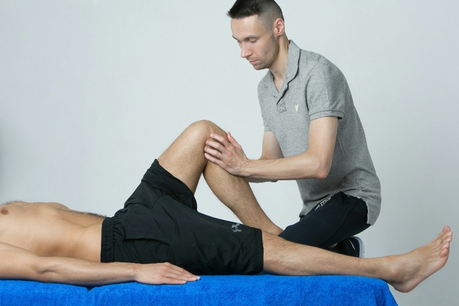 massage therapist working on an athlete’s leg muscles to enhance performance and muscle recovery