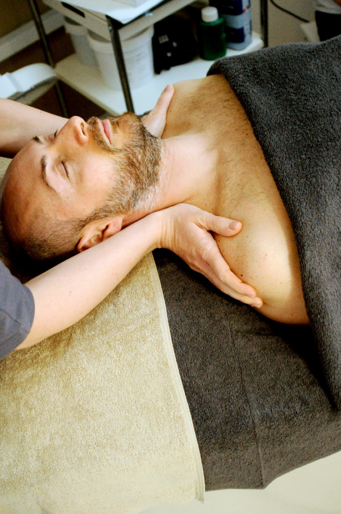 Therapist performing a gentle neck and shoulder massage to relieve stress and tension.