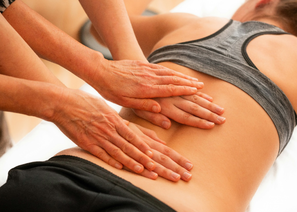 Therapist performing deep tissue massage on a client’s lower back to enhance mobility and reduce stiffness.