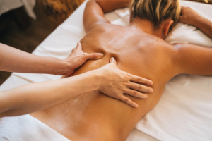 therapist applying firm pressure on client’s back during a massage