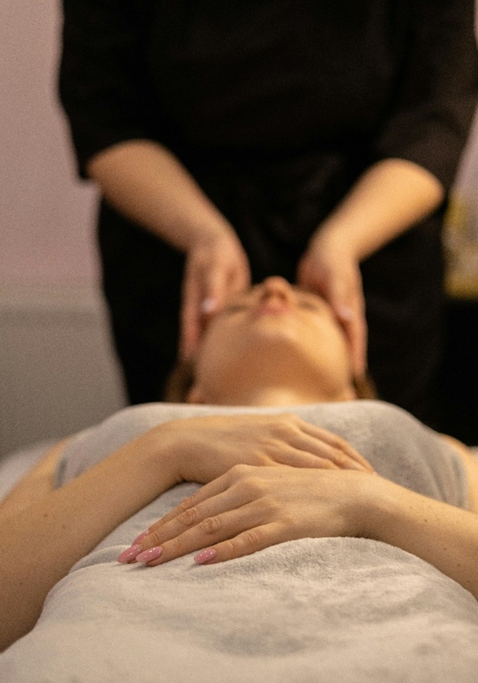 Massage therapist applying soothing facial massage to ease stress and enhance relaxation.