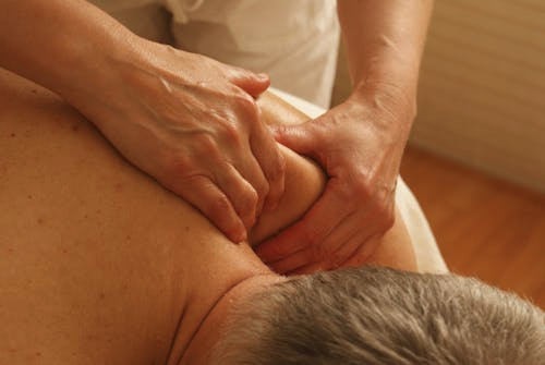 therapist applying deep pressure on client’s shoulder