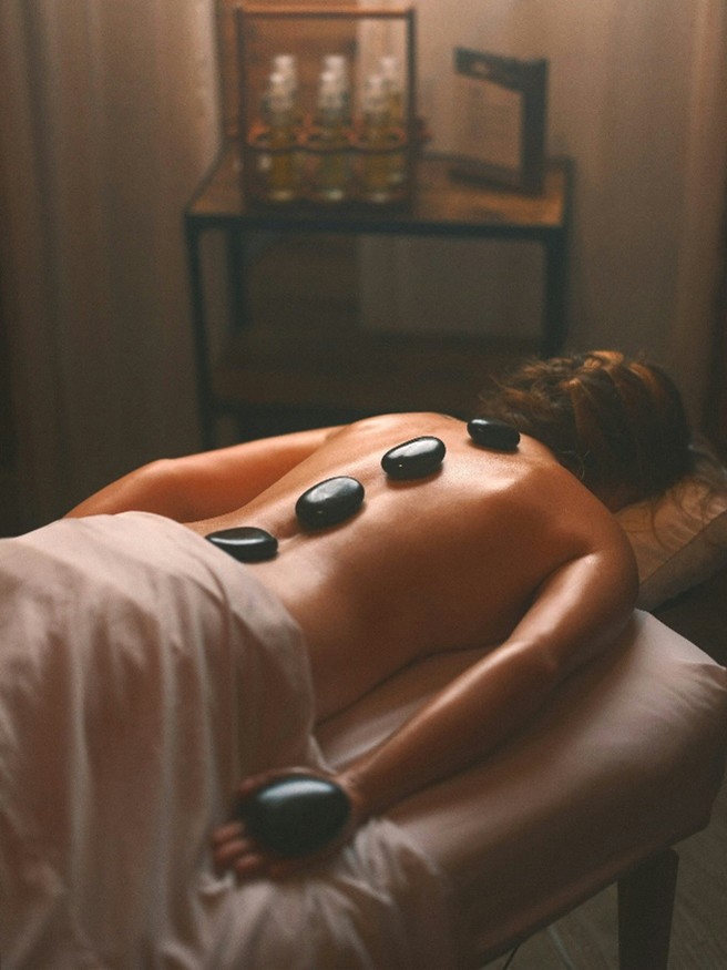 Warm basalt stones placed along the spine during a hot stone massage session.