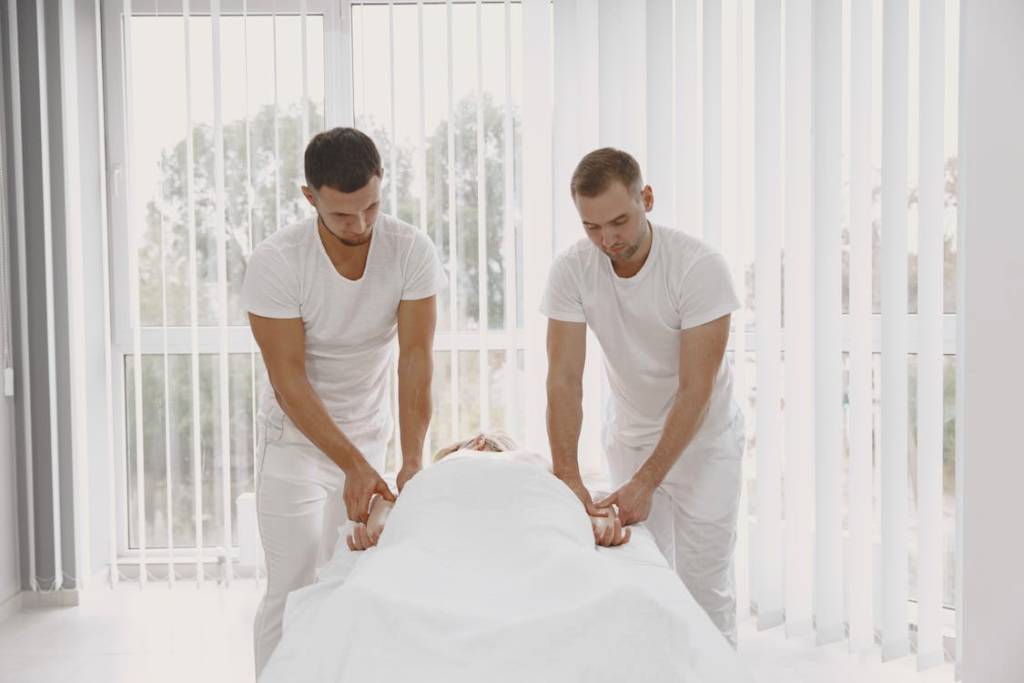 Professional massage therapists preparing a treatment room