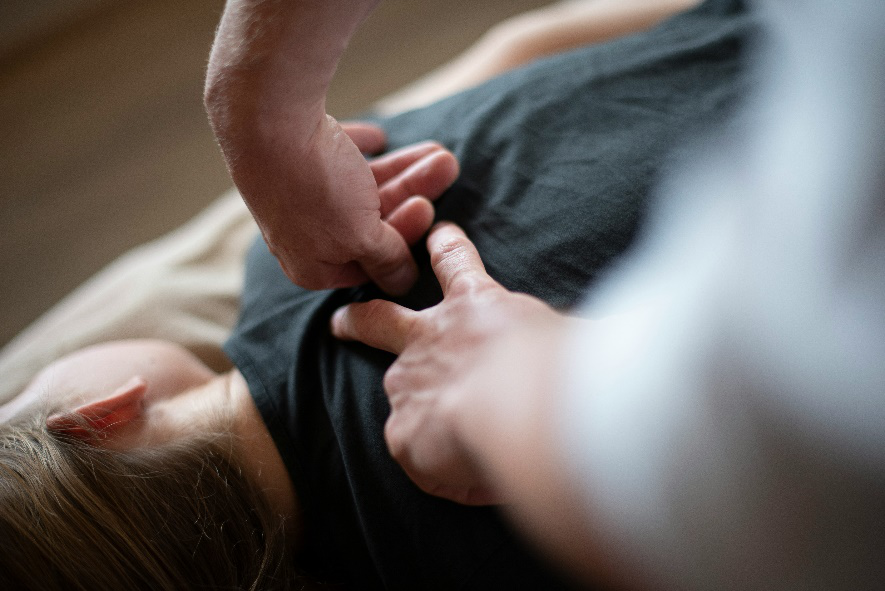 Therapist applying precise pressure to upper back muscles to relieve stiffness and tension.