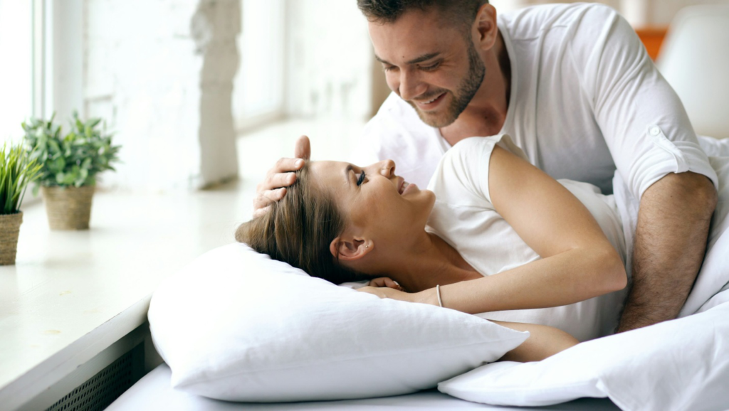 A Couple smiling and sharing a tender moment, reflecting the strengthened emotional connection that follows a romantic couples massage in Edmonton.
