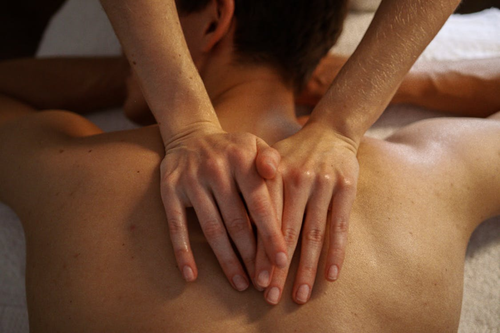 Therapist applying concentrated pressure across the upper back to break down deep knots and improve mobility.