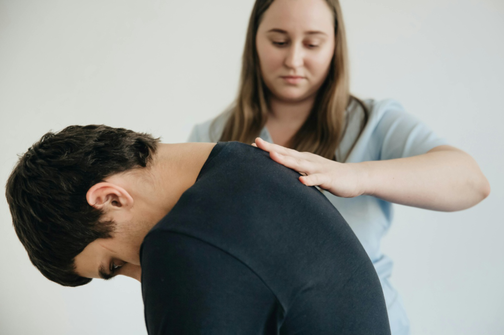 a massage therapist helping a client exercise their back