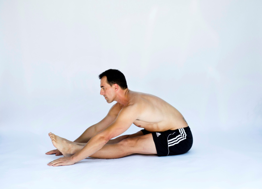 A man stretching his body towards his feet