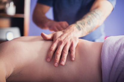 Therapist applying a back massage to support circulation and muscles recovery
