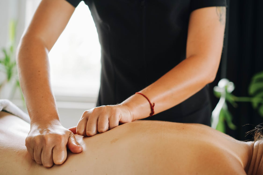 close-up of a massage therapist massaging a client's back using the kneading technique