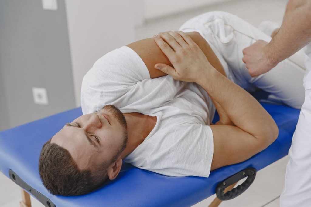 a man having a massage while lying on a blue massage table