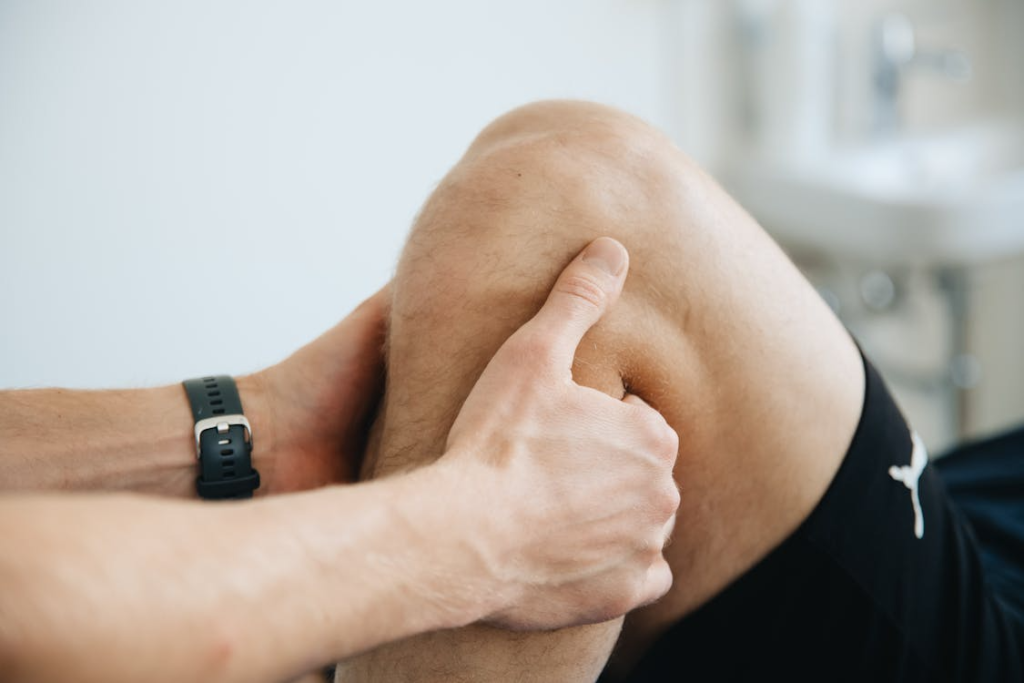 a massage therapist massaging the knee and leg of a recovering client