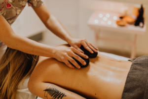 a woman lying and getting a hot stone massage