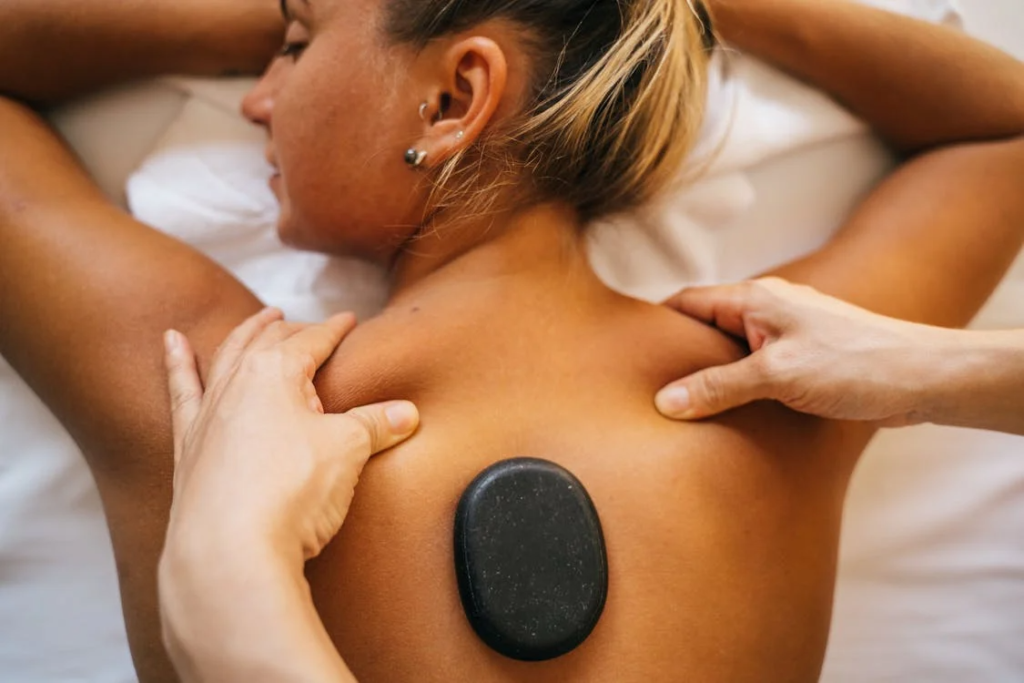 a woman getting a relaxation massage along with a hot stone massage