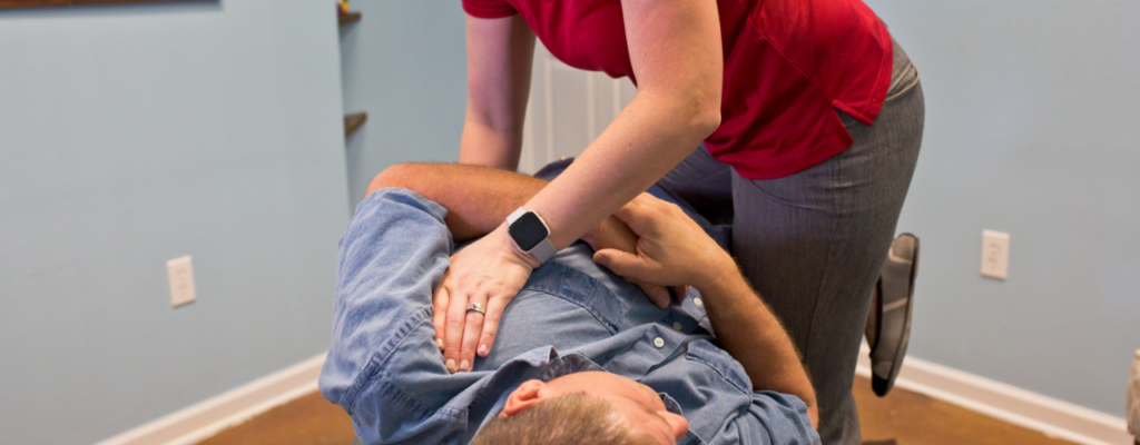 A person helping with another person’s back problems.