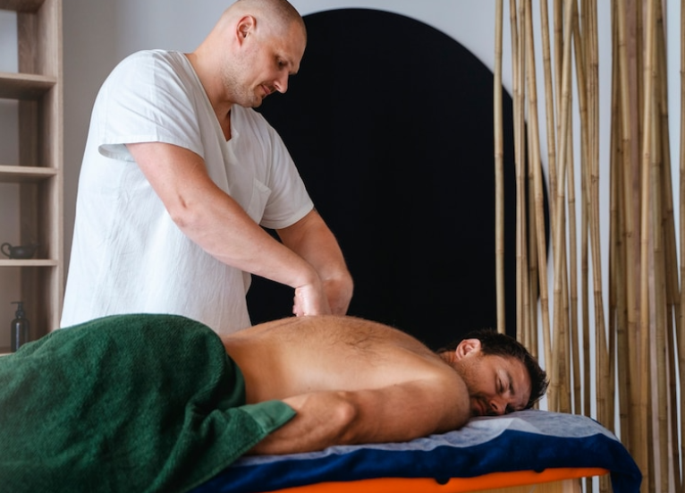 A person massaging another person’s back.