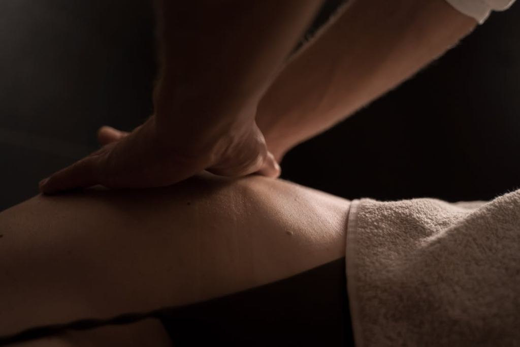 close-up of a masseuse doing a deep tissue massage on a client covered in a towel
