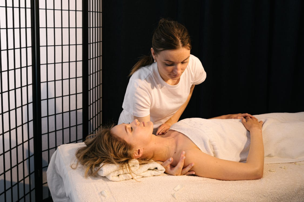 a woman getting a shoulder massage with a towel over her