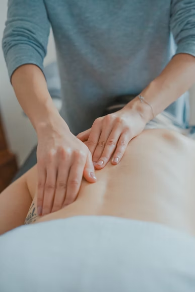 A person massaging a client’s back.