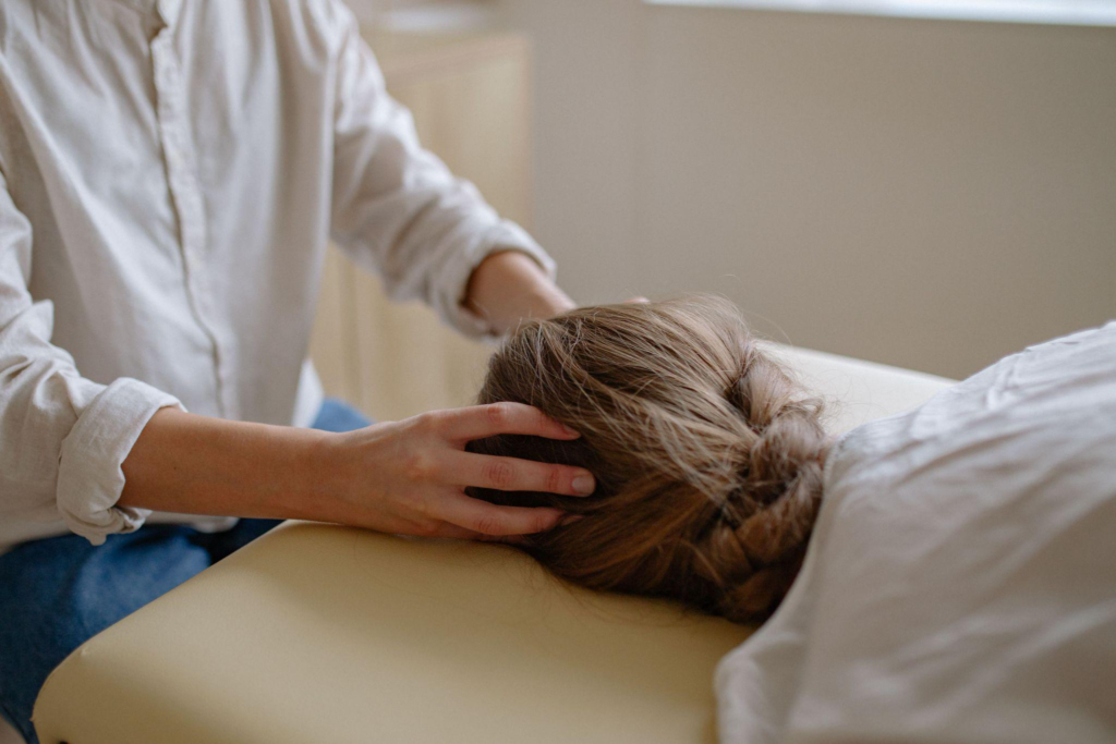 a massage therapist massaging a person’s head