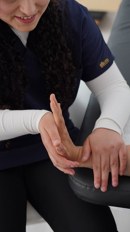 a therapist providing hands-on care for a person’s wrist and hand