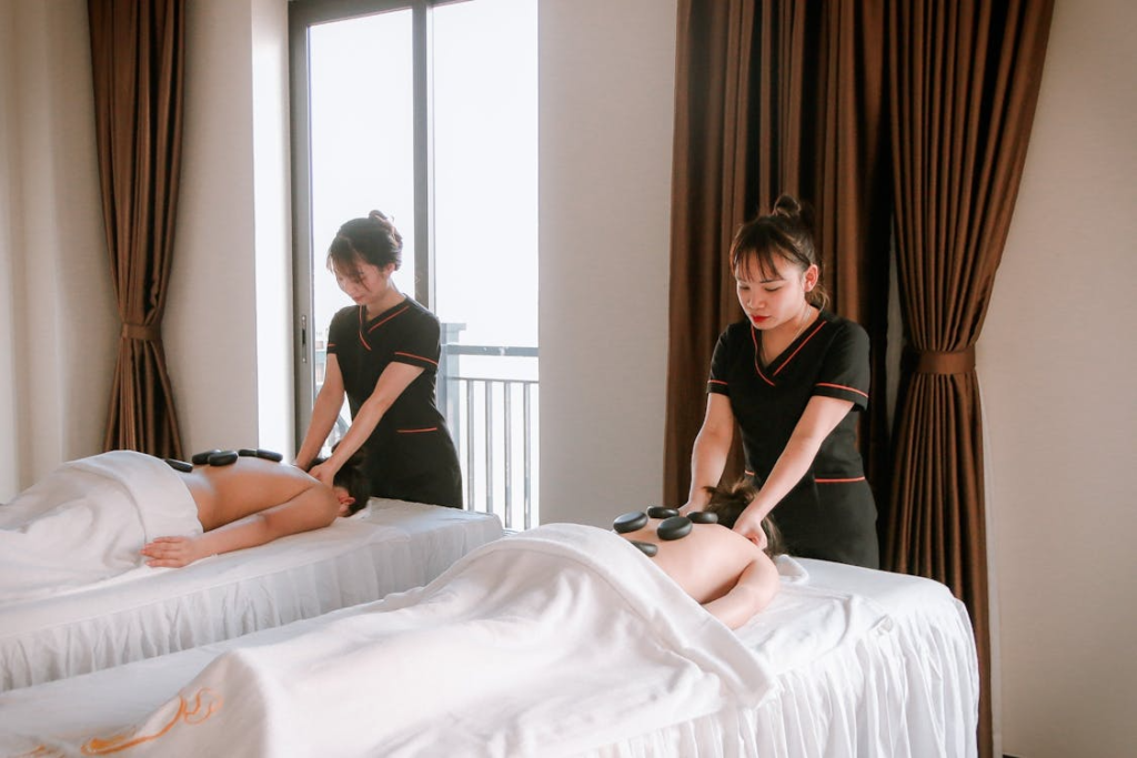 two people receiving side-by-side hot stone massage treatments