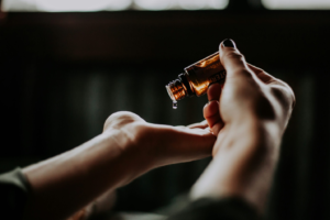 A person pouring oil in their palms.