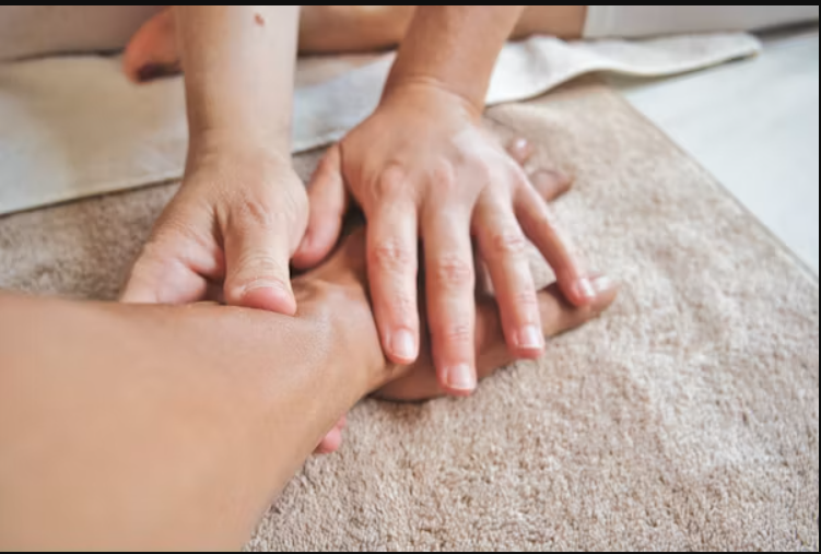 A person massaging another person’s hand.