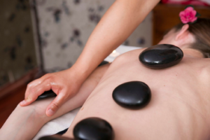 A person with hot stones on their back for relaxation.