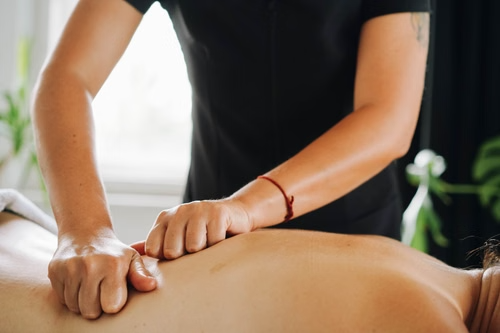 A massage therapist massaging a client’s back