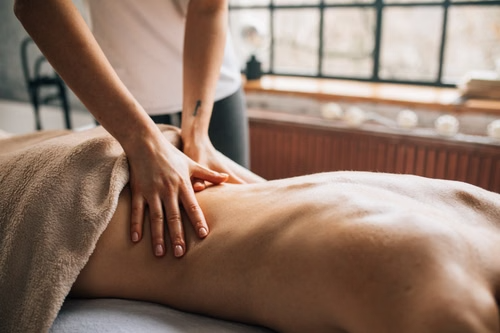 A massage therapist massaging a client’s lower back