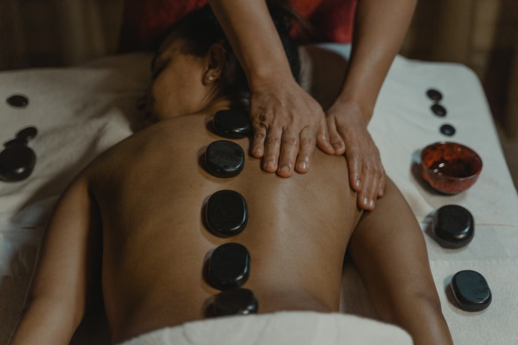 This photo shows a woman getting a hot stone massage.