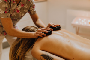 This photo shows a woman getting a hot stone massage.