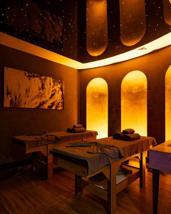 A large massage room with low lights.