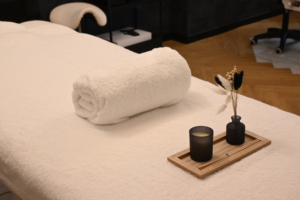 This photo shows a massage table with a lit candle and calming decor.